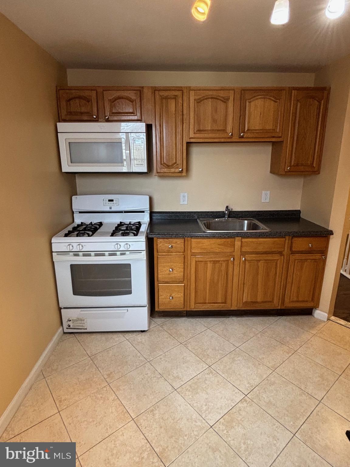 1911 72nd Avenue Philadelphia, PA 19138 - Photo 17 of 27 a kitchen with stainless steel appliances granite countertop a stove a sink and a microwave