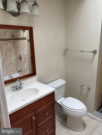 a bathroom with a sink vanity mirror and toilet