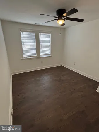 an empty room with windows and chandelier fan