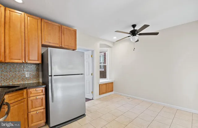 a white refrigerator freezer and a stove sitting inside of a kitchen