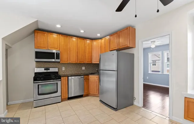 a kitchen with stainless steel appliances granite countertop a refrigerator a stove a sink and a microwave