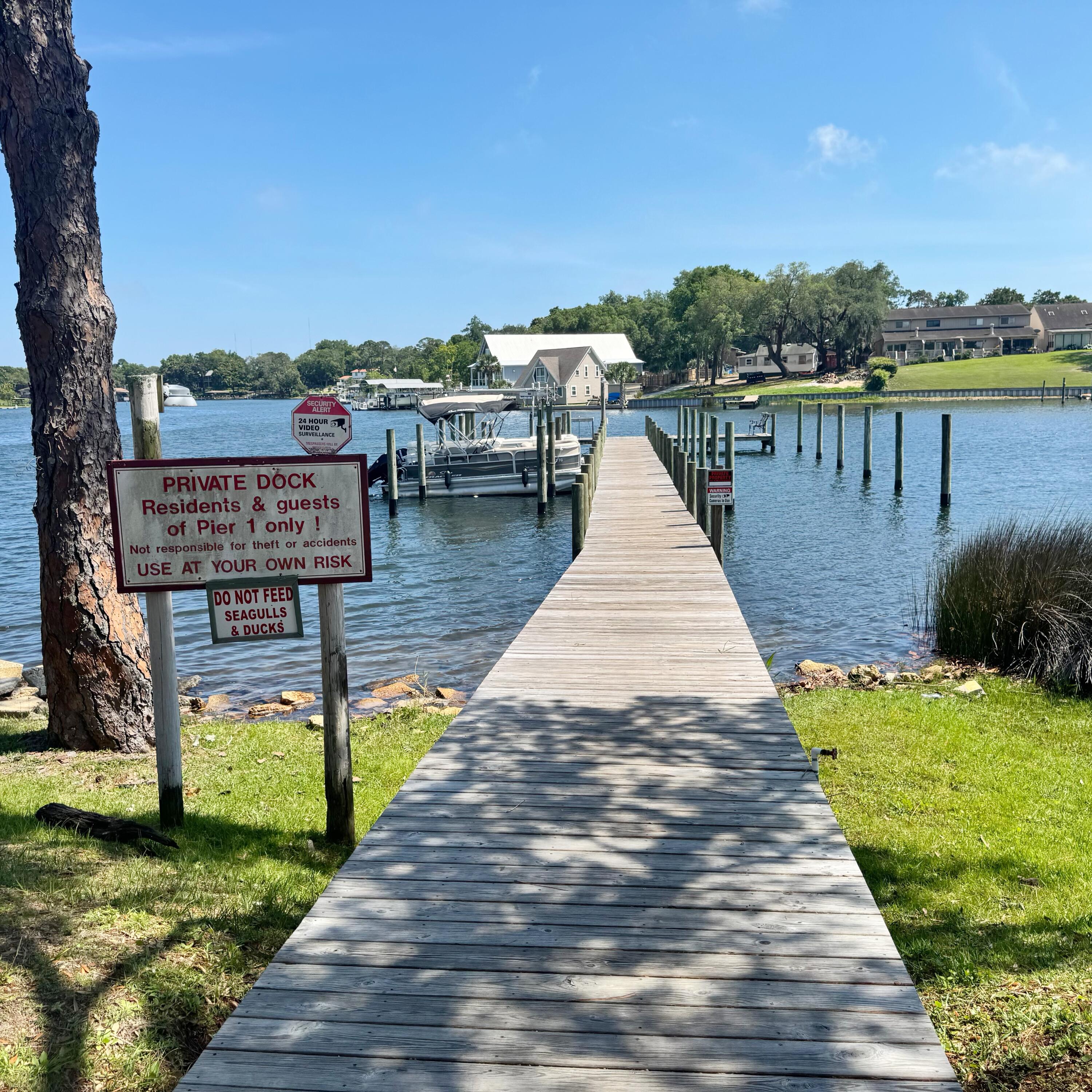 210 Pelham Road, Unit 215B Fort Walton Beach, FL 32547 - Photo 22 of 23 a view of a lake with a bench next to a lake