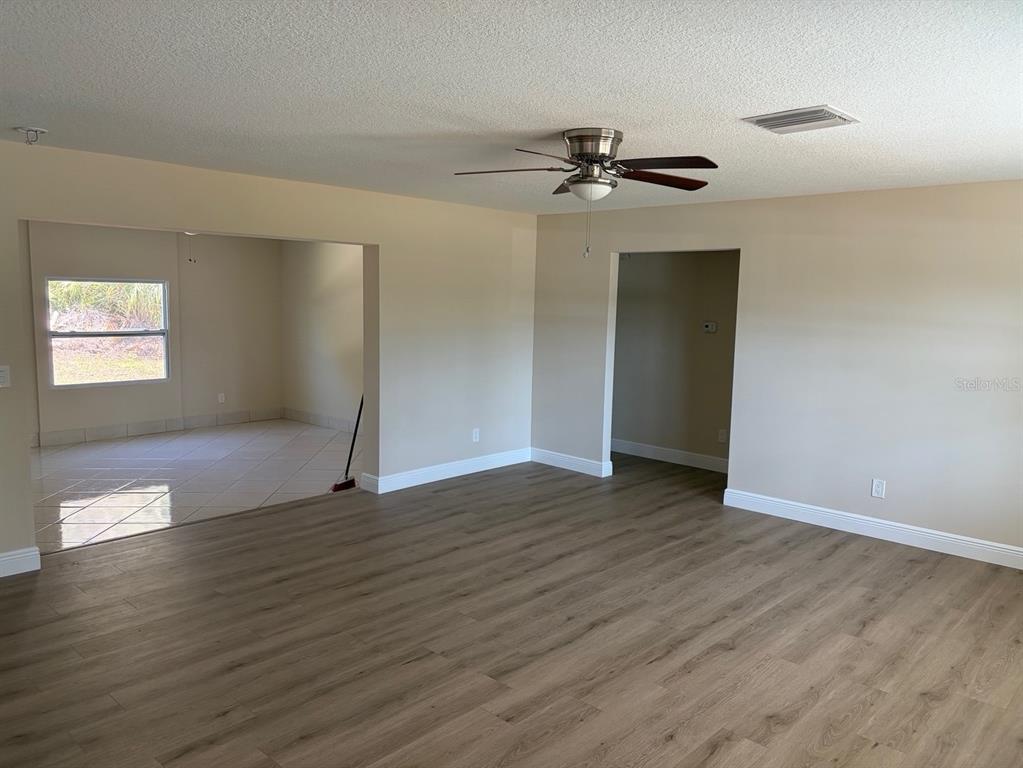 201 Palmetto Road West Nokomis, FL 34275 - Photo 5 of 17 an empty room with wooden floor closet and fan