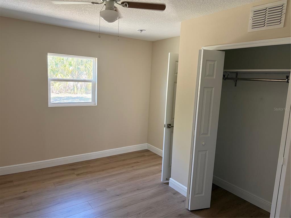 201 Palmetto Road West Nokomis, FL 34275 - Photo 9 of 17 an empty room with wooden floor closet and windows