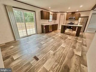 a kitchen with stainless steel appliances granite countertop a refrigerator a stove and a sink