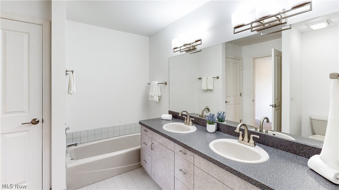 3700 Chagrin River Road Chagrin Falls, OH 44022 - Photo 19 of 43 Bathroom with dual vanity, a washtub, toilet, and tile patterned floors