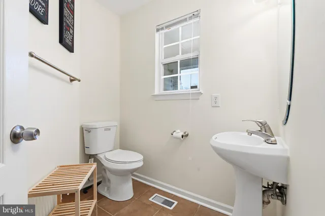 a bathroom with a sink toilet and a mirror