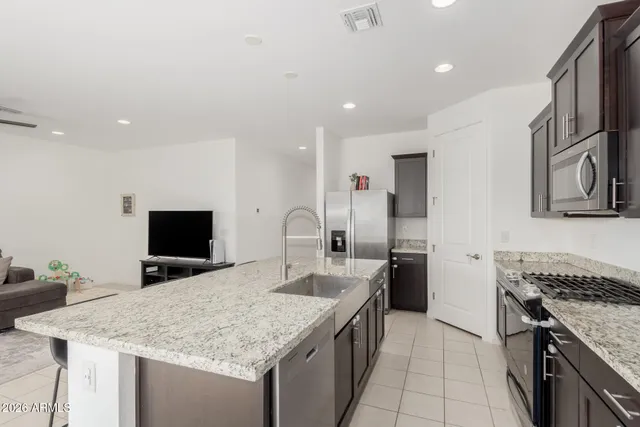 a kitchen with stainless steel appliances granite countertop a sink stove and refrigerator