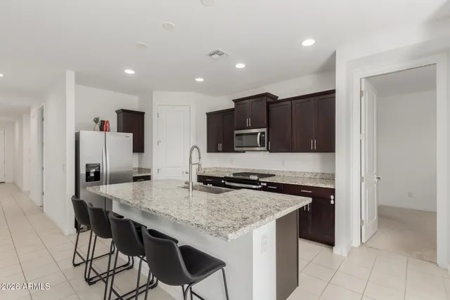 a kitchen with stainless steel appliances a stove top oven a refrigerator a sink and a counter