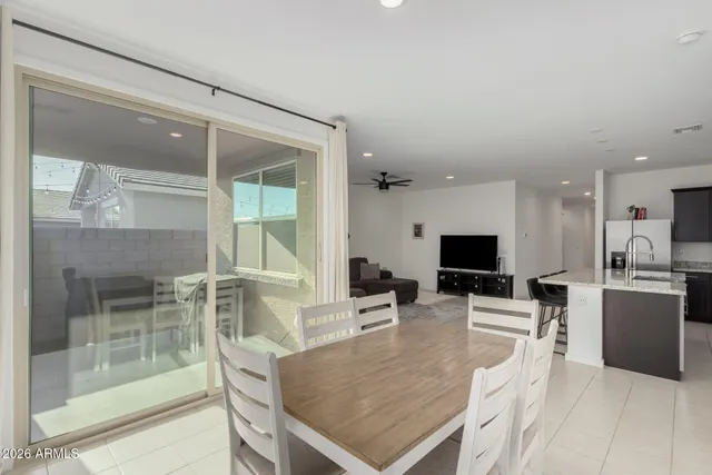 a dining hall with stainless steel appliances a dining table and chairs