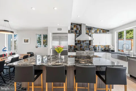 a kitchen with granite countertop a table chairs stove and granite counter top