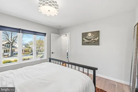 a view of a bedroom with wooden floor and a window