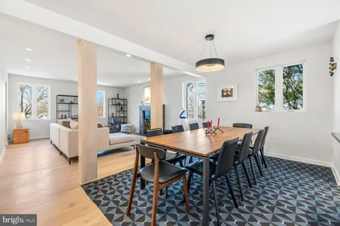 a view of a a dining room and livingroom with furniture wooden floor and a rug
