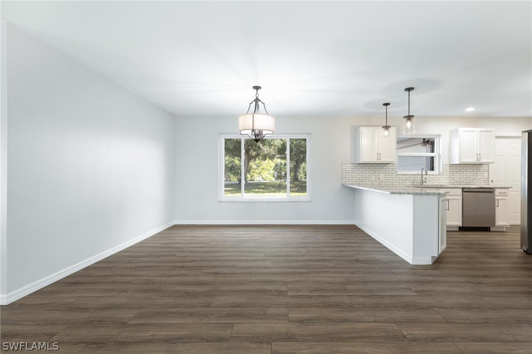 1453 River Road Moore Haven, FL 33471 - Photo 12 of 39 a view of kitchen and empty room with wooden floor