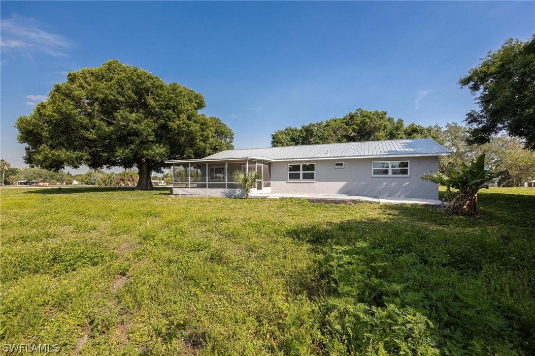 1453 River Road Moore Haven, FL 33471 - Photo 31 of 39 a front view of house with yard and trees in the background