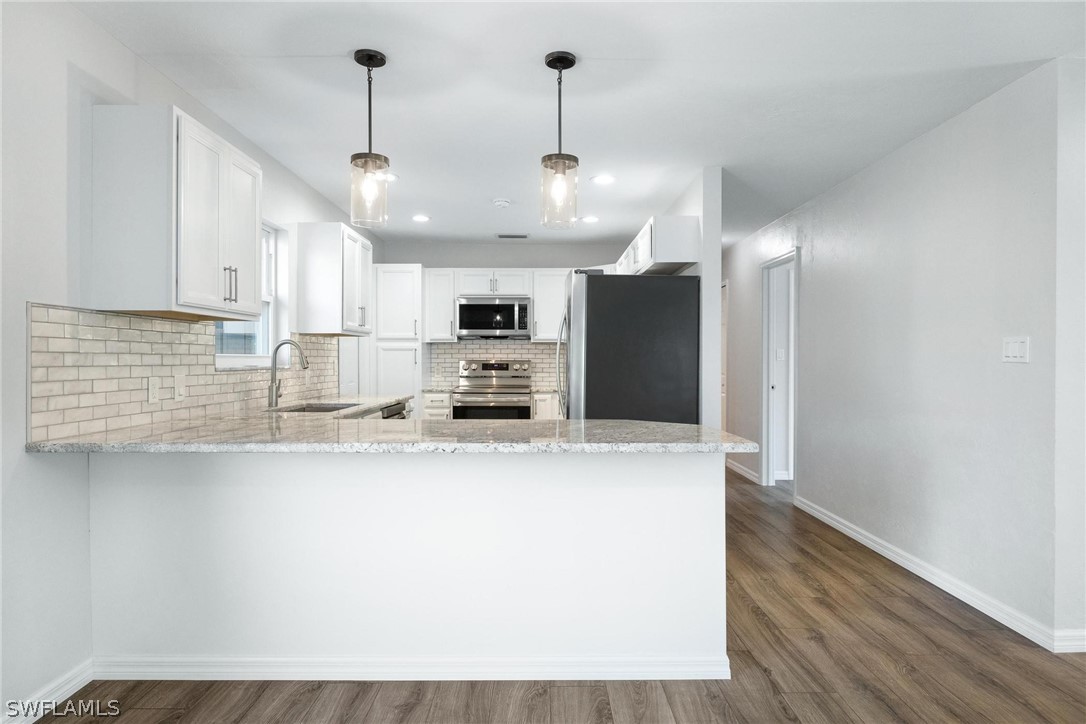 1453 River Road Moore Haven, FL 33471 - Photo 6 of 39 a large kitchen with stainless steel appliances a large counter top a stove a refrigerator and a sink