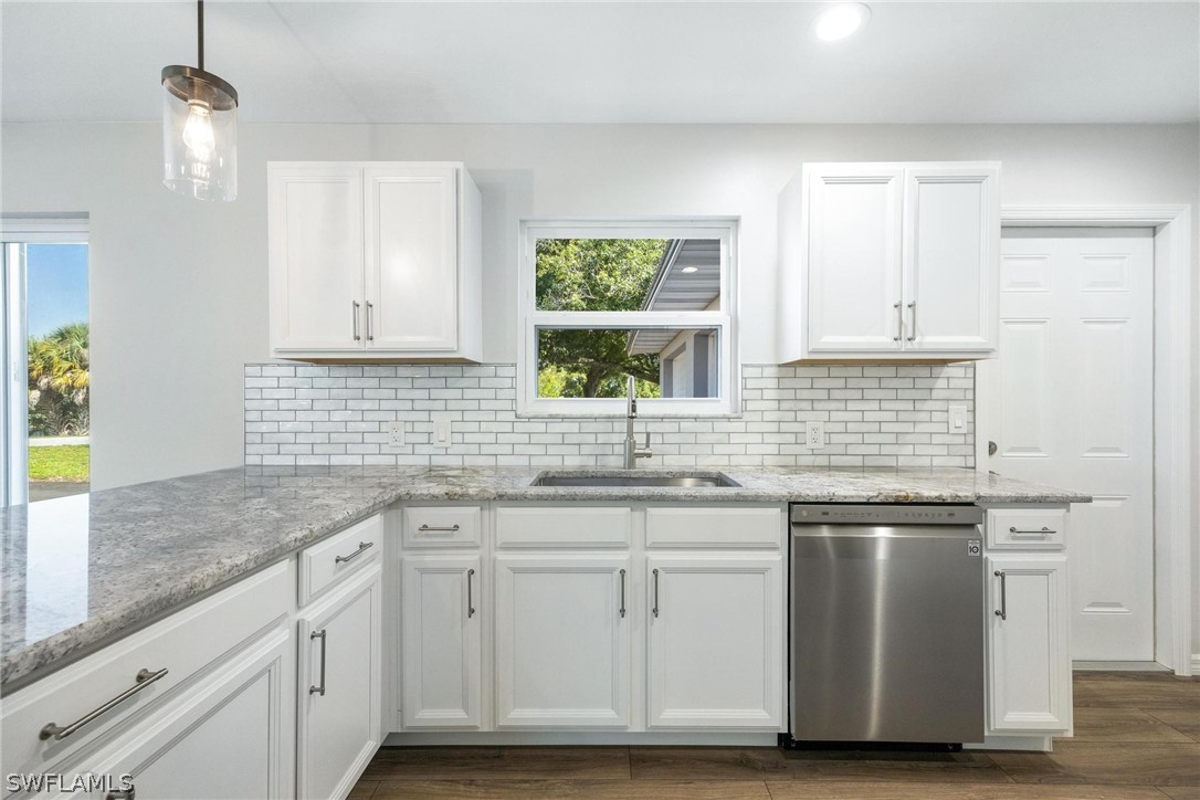 1453 River Road Moore Haven, FL 33471 - Photo 8 of 39 a kitchen with stainless steel appliances granite countertop a sink and dishwasher with wooden floor