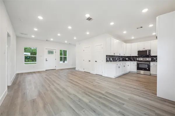 a view of an empty room with wooden floor