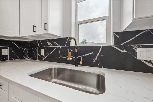 a kitchen with a sink and white cabinets