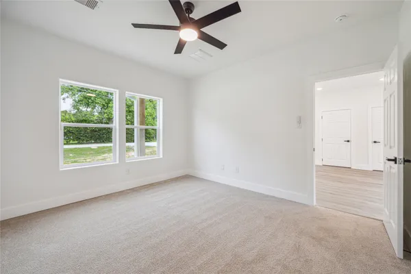 an empty room with a window and a fan
