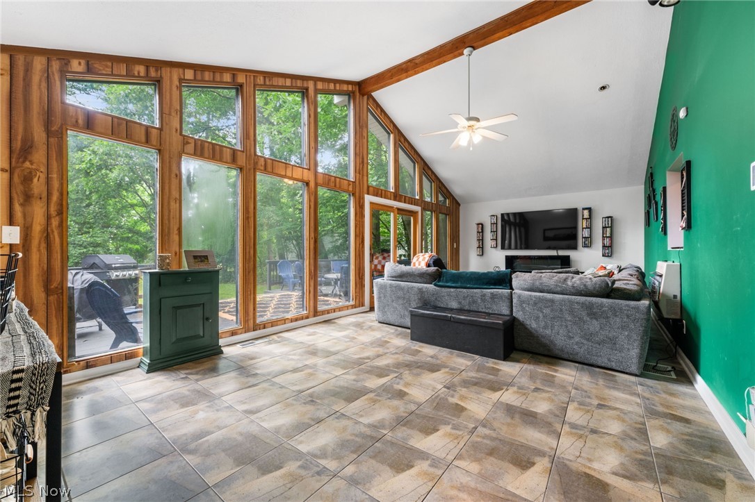 4159 Bluestone Road Cleveland, OH 44121 - Photo 14 of 42 Tiled living room featuring a healthy amount of sunlight, beamed ceiling, high vaulted ceiling, and ceiling fan