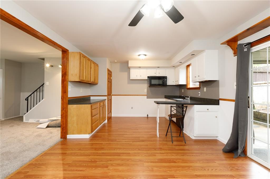 826 Ridge Avenue McKees Rocks, PA 15136 - Photo 9 of 22 a kitchen with stainless steel appliances kitchen island granite countertop a stove top oven a sink a dining table and chairs with wooden floor
