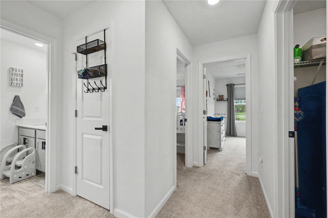3011 Falls Road Clayton, OH 45315 - Photo 45 of 66 A well-lit hallway connects various rooms, featuring clean lines and a neutral color palette.