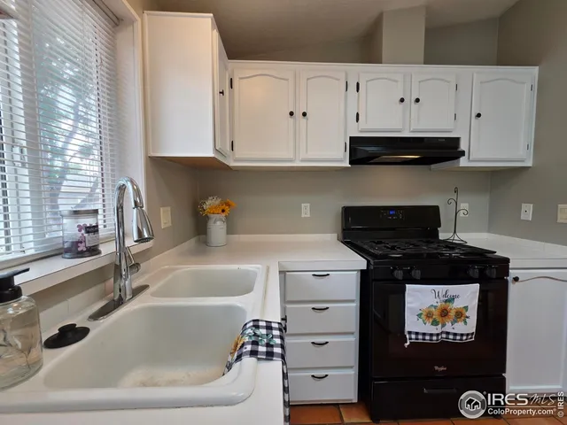 a kitchen with white cabinets and black appliances