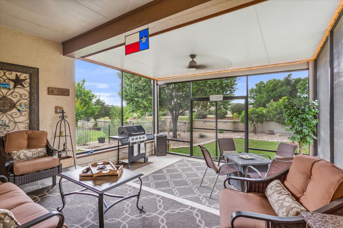 Screened Sunroom with entertaining space, ceiling fan and lighting.