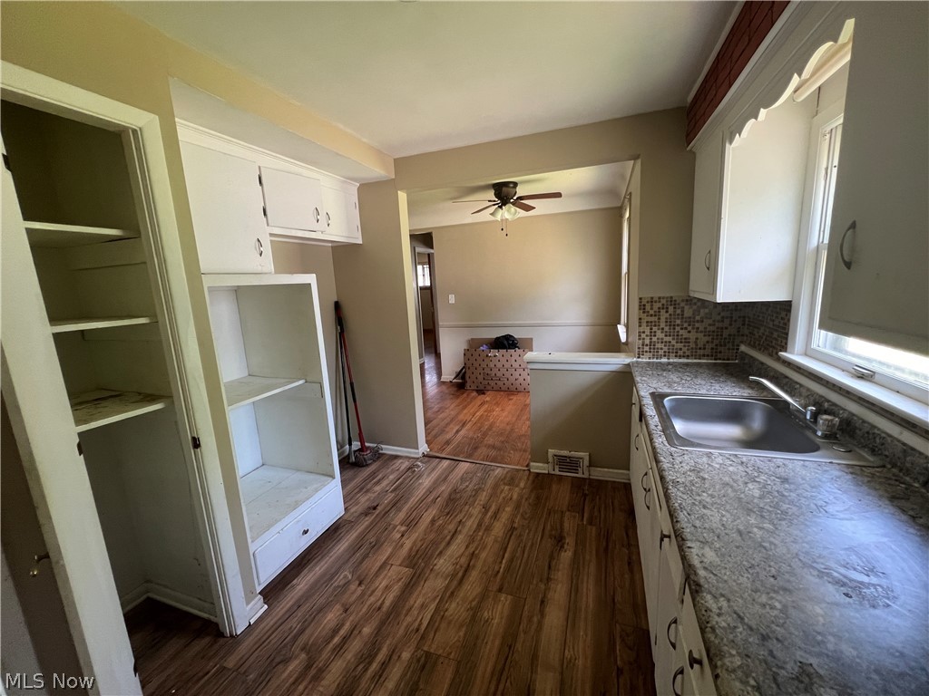 20731 Donnybrook Road Maple Heights, OH 44137 - Photo 3 of 17 Kitchen featuring sink, backsplash, dark hardwood / wood-style floors, white cabinetry, and ceiling fan