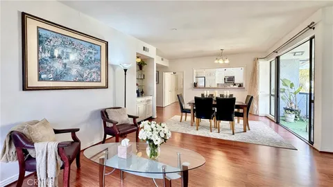 a dining room with wooden floor a glass table and chairs