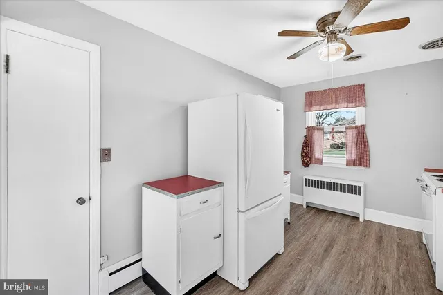 a hallway with chandelier and wooden floor