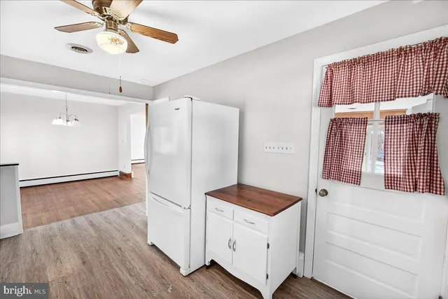 a kitchen with a refrigerator and a ceiling fan