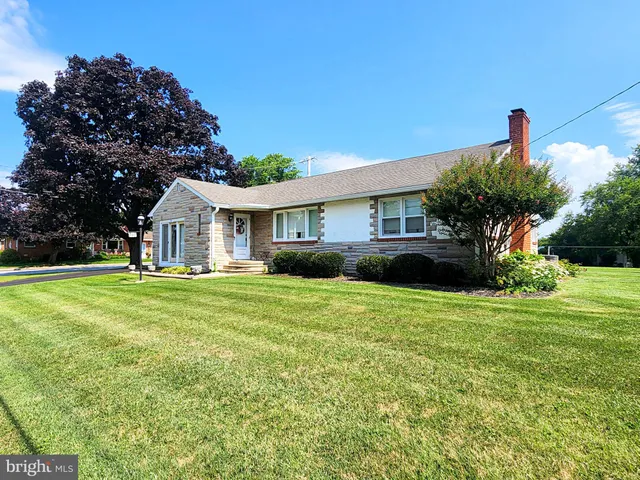 a front view of a house with a yard and trees