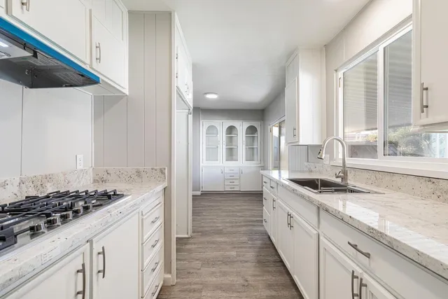 a kitchen with sink stove and cabinets