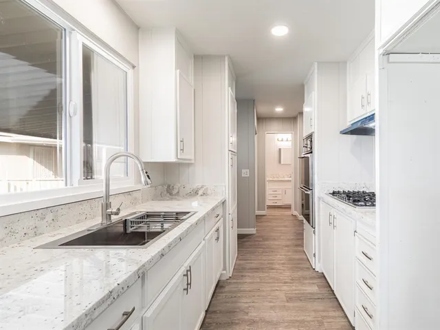 a kitchen with a sink stove and cabinets