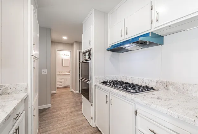 a kitchen with stainless steel appliances a refrigerator and a stove top oven