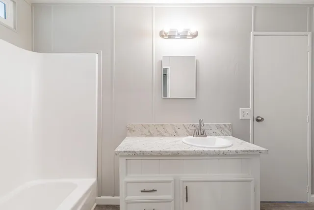 a bathroom with a granite countertop sink and a mirror