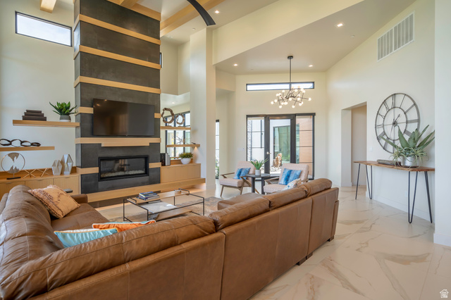 3606 South Cypress Road Hurricane, UT 84737 - Photo 14 of 69 Living room with a fireplace, light marble finish floors, a high ceiling, and a chandelier
