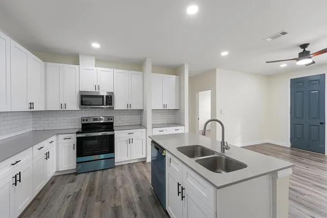 a kitchen with stainless steel appliances granite countertop a sink stove and refrigerator
