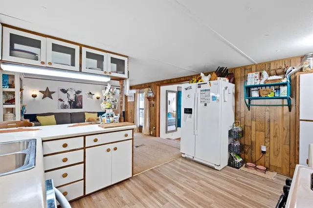 a kitchen with a dining table chairs and refrigerator