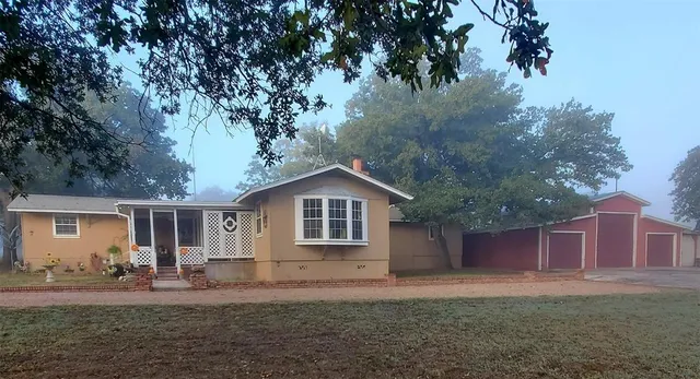 a front view of a house with a yard and trees