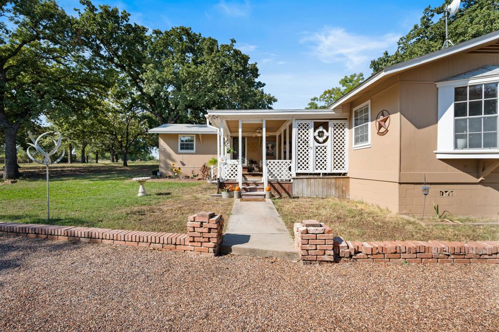 1500 County Road 404 Comanche, TX 76442 - Photo 4 of 39 a front view of a house with garden