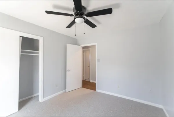 an empty room with a ceiling fan and a window