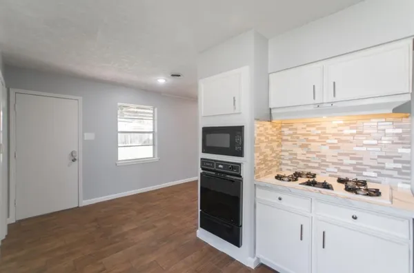 a kitchen with granite countertop white cabinets and appliances