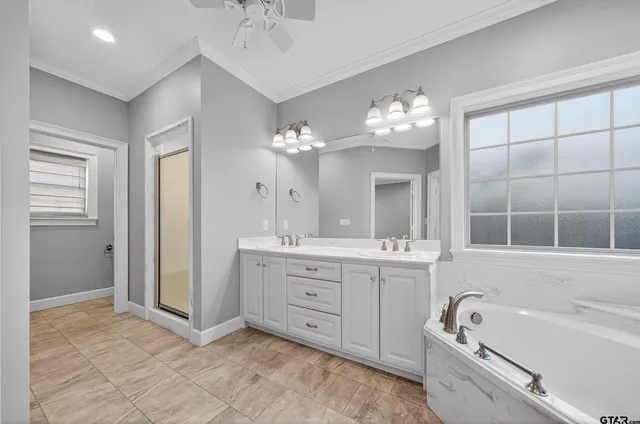 a spacious bathroom with a tub sink and mirror