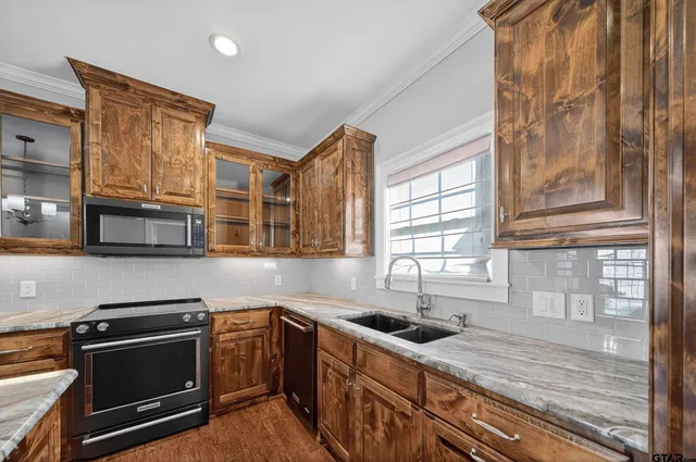 a kitchen with stainless steel appliances granite countertop a stove a sink and a microwave