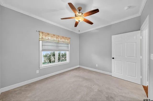 an empty room with ceiling fan and window