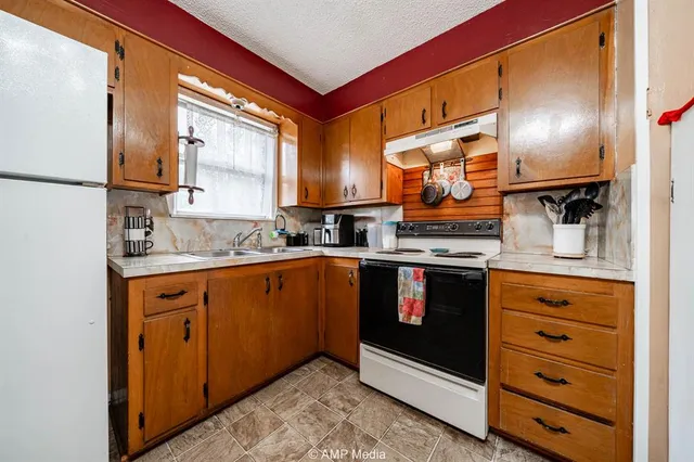 a kitchen with stainless steel appliances granite countertop a microwave a sink and a refrigerator