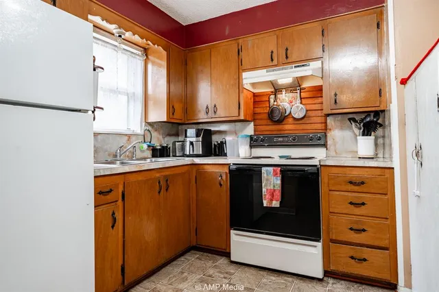 a kitchen with kitchen island a counter top space a sink stainless steel appliances and cabinets